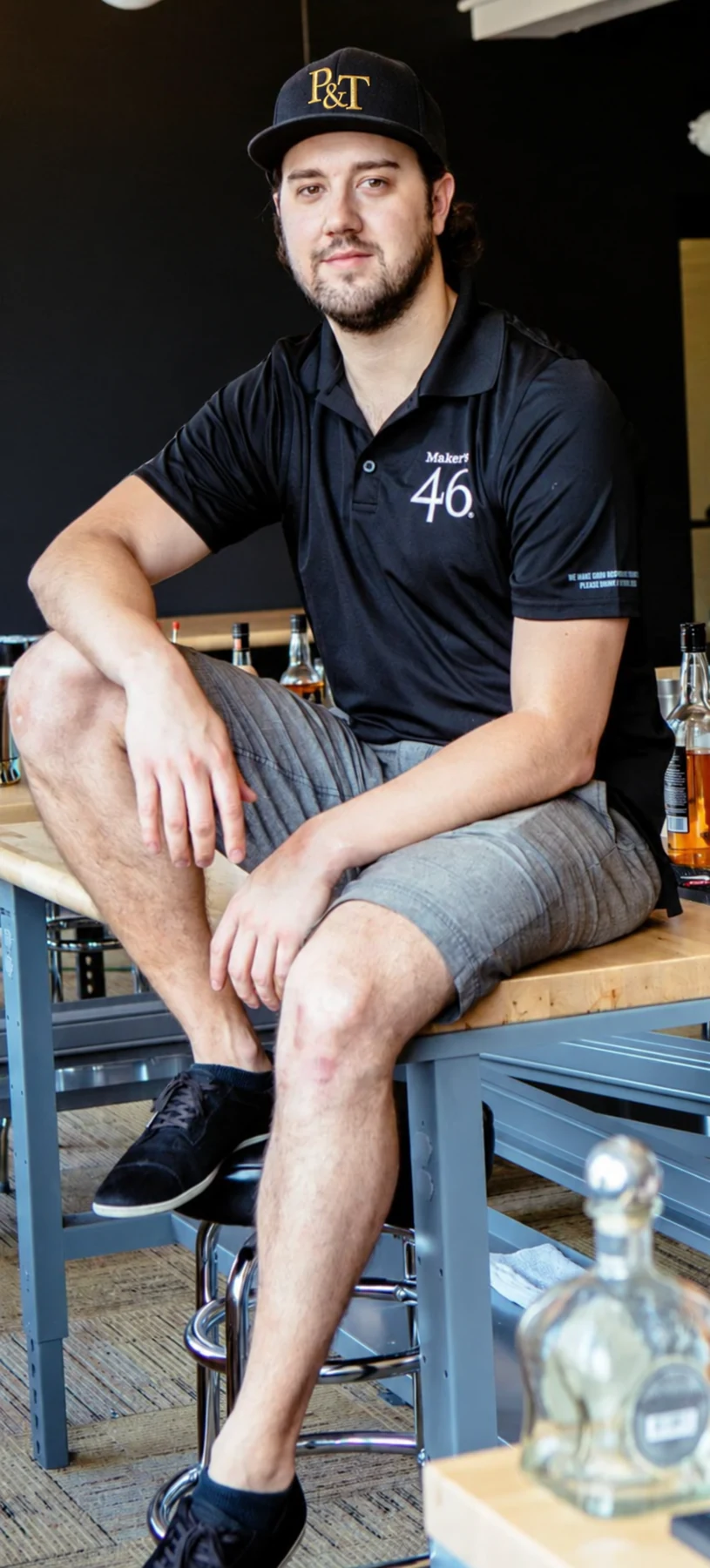 Owen wearing a Pour & Tell cap at a cocktail station.