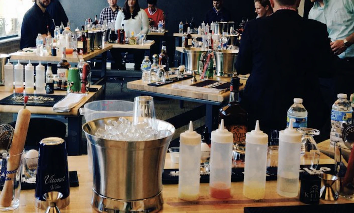 Guests gathered around individual cocktail-making stations during a hands-on class.